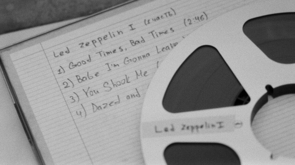 Close-up of a retro reel and handwritten music notes, evoking nostalgia.