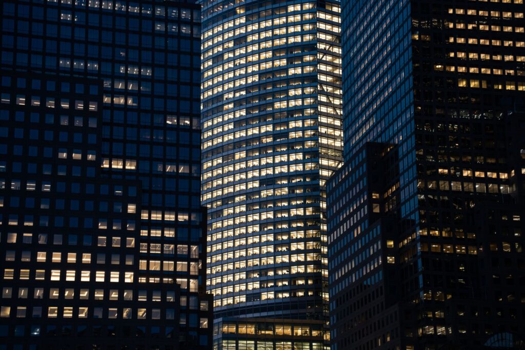 Glass office towers lit up floor by floor at night